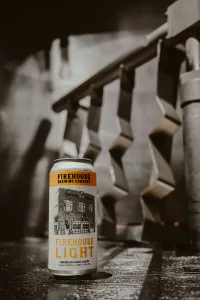 Beer can on black and white photo with yellow label. Firehouse Light beer