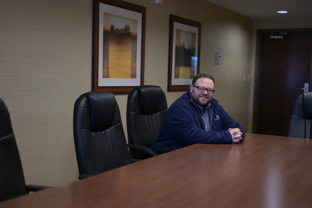 Clint Cox sits at board room table