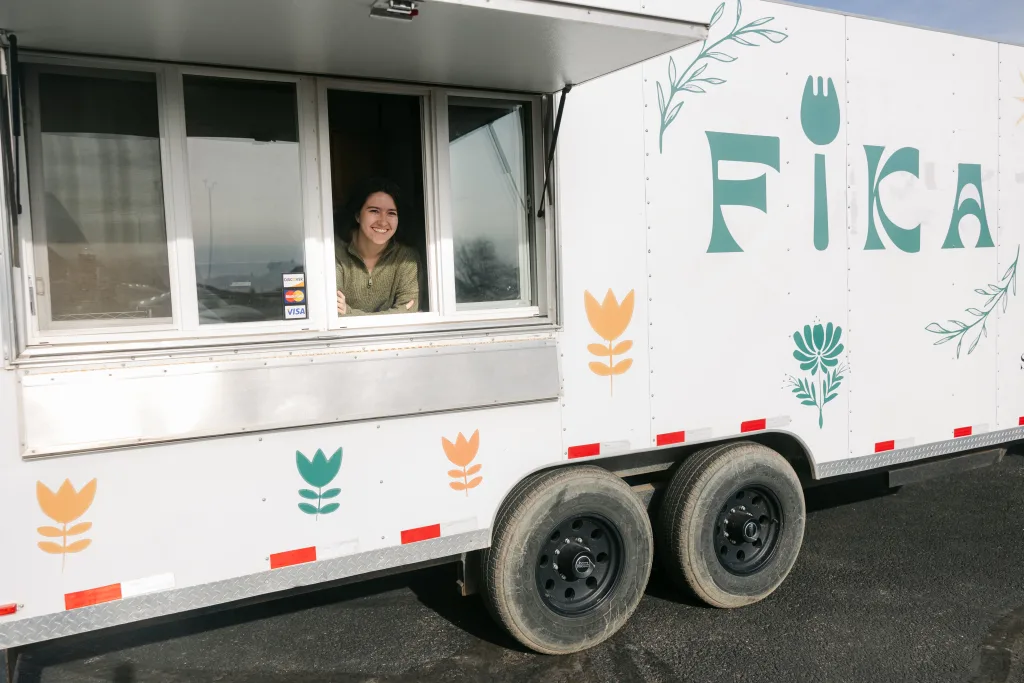 Jess Tolman-Stickney inside white FIKA Food truck