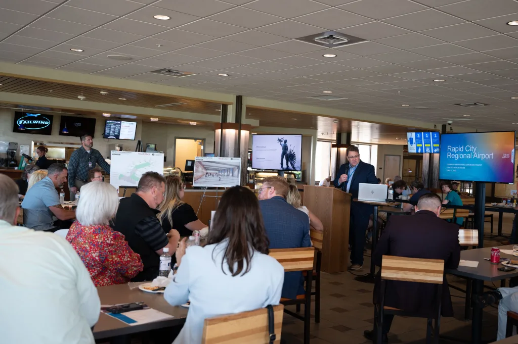 Patrick Dame, Executive Director of Rapid City Airport, speaks in front of a crowd