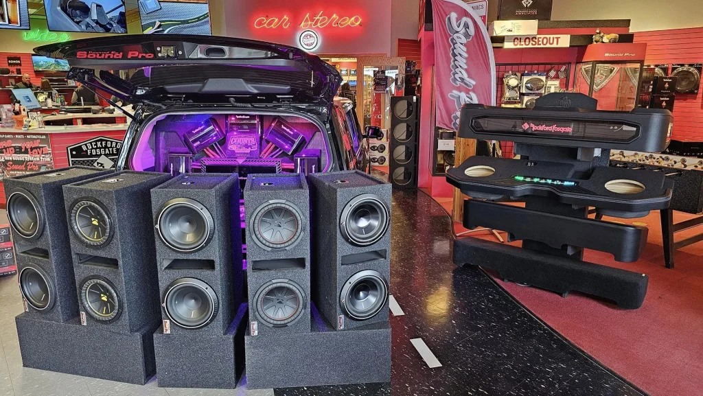 Sound Pro store display with 10" subwoofer speakers in front of a vehicle with trunk open