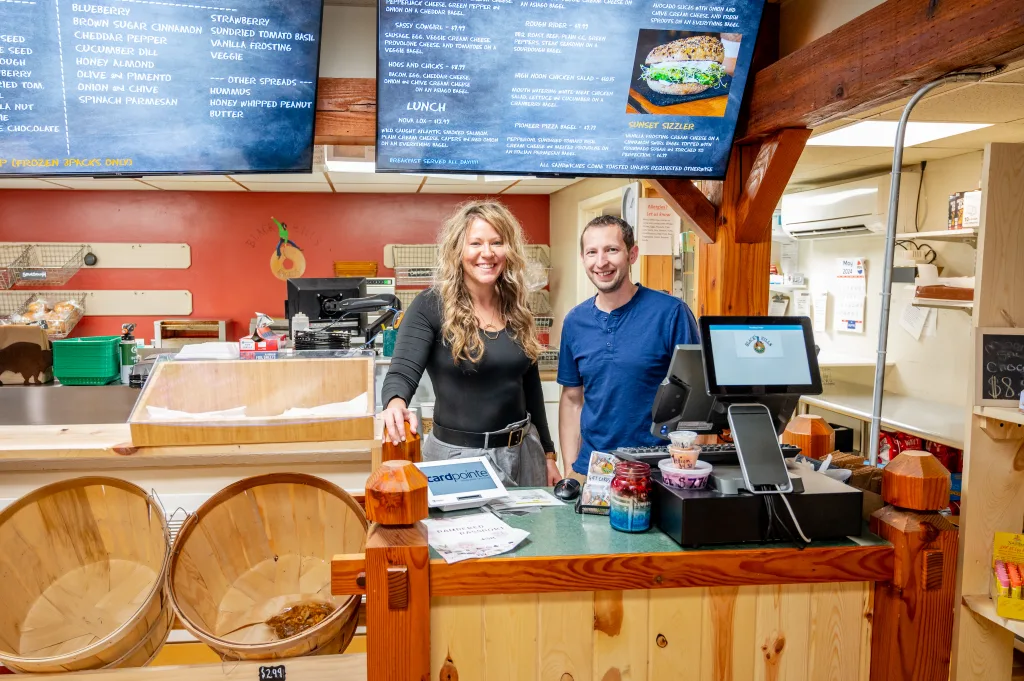 Marla Eric Hawronsky Black Hills Bagels owners behind cash register of bagel shop