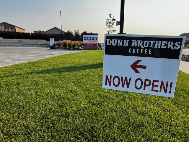 Yard Sign Reads Dunn Brothers Coffee now Open with red arrow pointing left