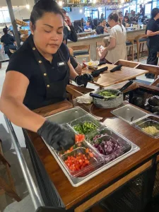 a woman makes made to order guacamole at the table of ma cualli