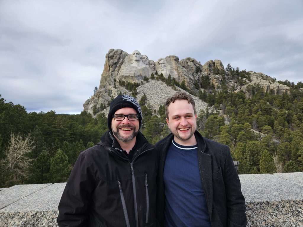 Paul and Tim Freidel stand in front of Mount Rushmore