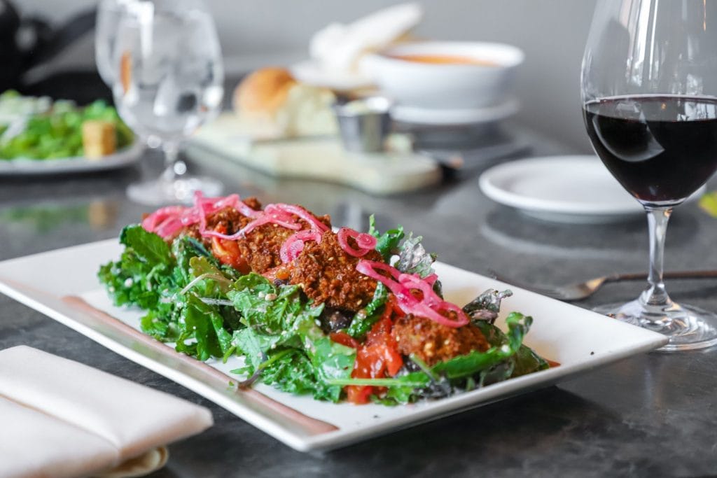 Plate of salad greens topped with pickled onions at Delmonico Grill Rapid City Restaurant Week special.