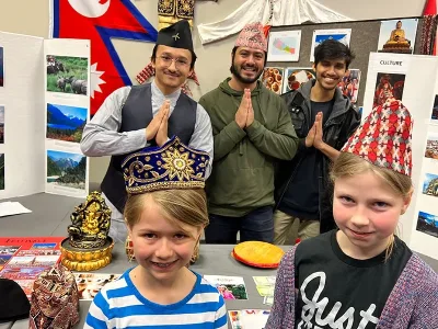 Children pose with traditional hats at cultural expo booth