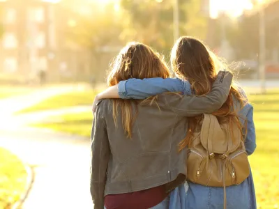 Affectionate friends walking at sunset in a park