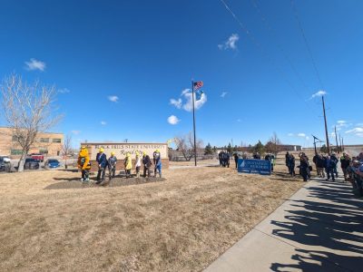 Elected officials stand with shovels in front of black hills state university rapid city sign for groundbreaking